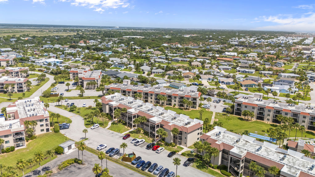 Aerial view of Ocean Village Club condo building with palm trees and walkways