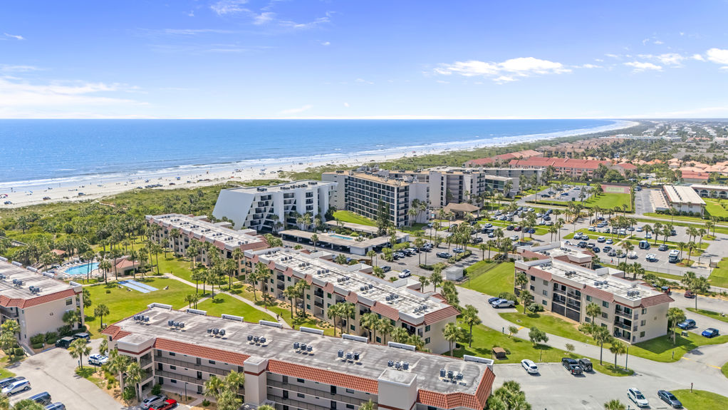 Aerial view of Ocean Village Club condo building with palm trees and walkways
