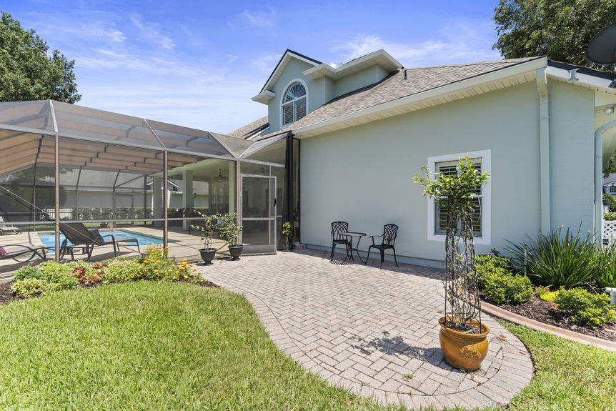 Sparkling blue pool with spa and screened enclosure overlooking water and greenery