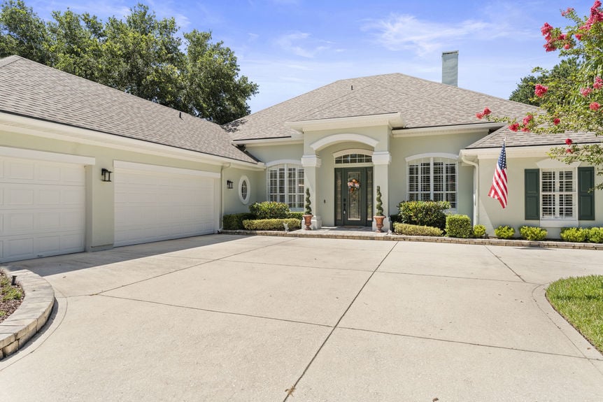 Front view of a luxury home in St Augustine Florida with palm trees and double garage