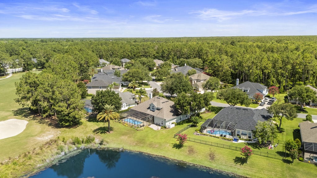 Neighborhood with golf course, water feature, and homes surrounded by trees in Florida
