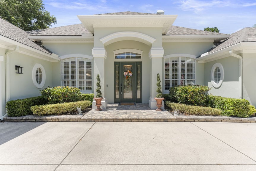 Front view of a luxury home in St Augustine Florida with palm trees and double garage