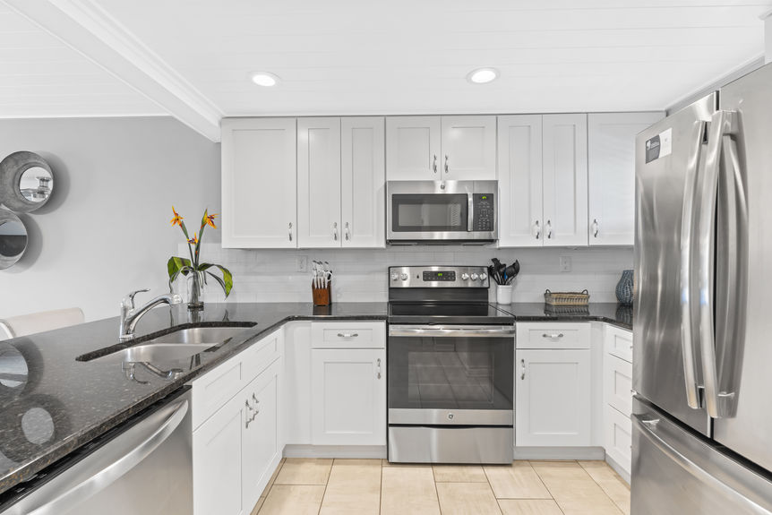 Updated white kitchen with stainless steel appliances and granite countertops