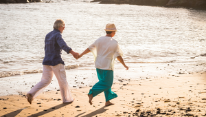 Smiling older couple walking on Palm Coast beach