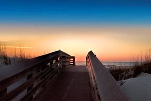 Wooden boardwalk leading through sand dunes to pristine beach at Anastasia State Park Florida