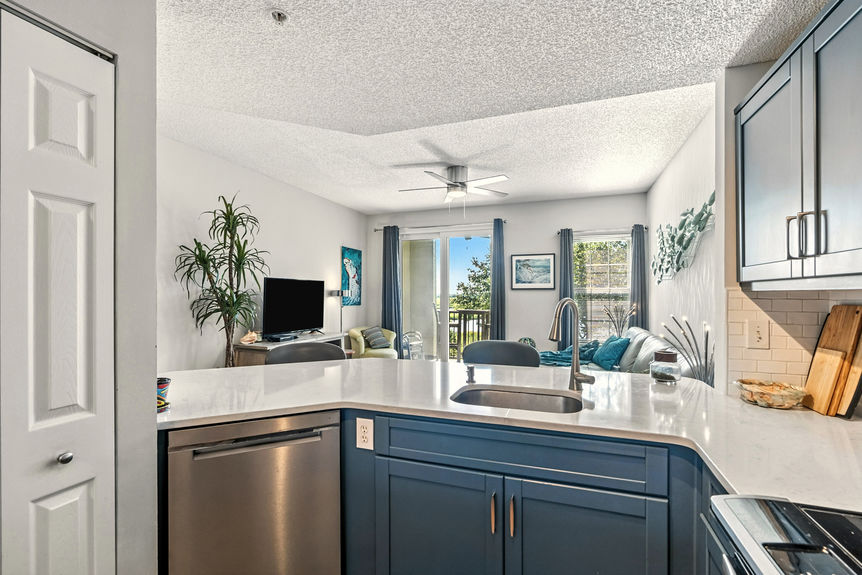 Modern kitchen with quartz countertops, stainless steel appliances, and blue cabinetry