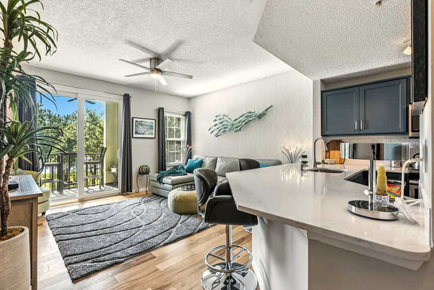 Bright open living room with marsh view balcony and updated interior finishes
