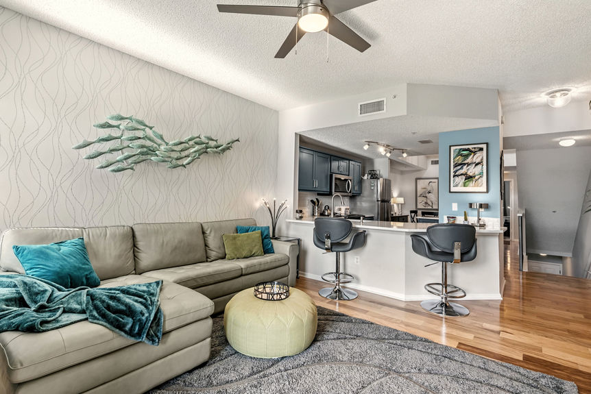 Bright open living room with marsh view balcony and updated interior finishes