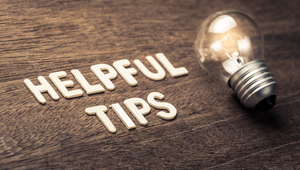 Light bulb next to “Helpful Tips” text on wood background, symbolizing relocation tips for newcomers to St. Augustine Florida.