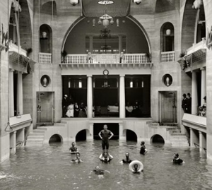 Historic indoor pool scene at the Lightner Museum in St. Augustine, Florida, with people swimming in a grand architectural setting