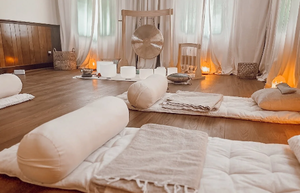 Tranquil wellness space prepared for a sound bath session with mats, cushions, blankets, and a large gong at Oldest City Arts & Wellness Lounge in St Augustine, Florida.