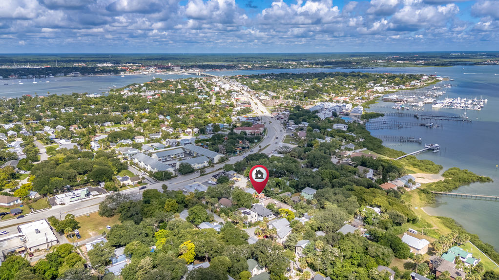 Drone view of St Augustine Florida neighborhood with homes, waterfront, boats, and nearby coastline.