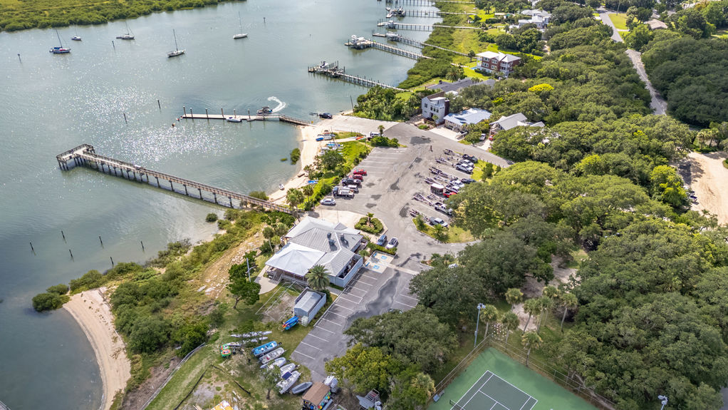 Drone view of St Augustine Florida neighborhood with homes, waterfront, boats, and nearby coastline.