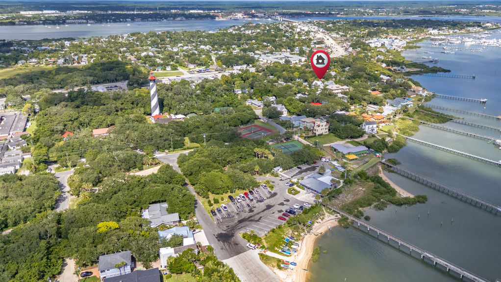 Drone view of St Augustine Florida neighborhood with homes, waterfront, boats, and nearby coastline.