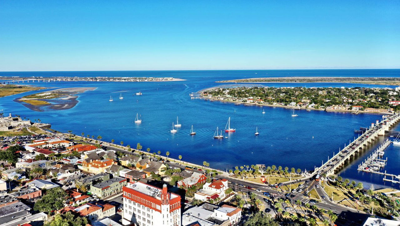 Aerial view of St. Augustine Florida showing the Intracoastal Waterway, historic downtown, marina, and coastal homes, highlighting living in St. Augustine and nearby real estate.