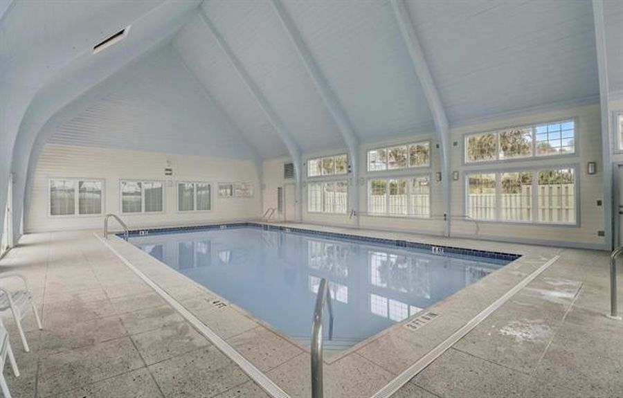 Large indoor heated swimming pool with a vaulted ceiling and expansive windows at the Villages of Vilano gated community in St. Augustine, FL.