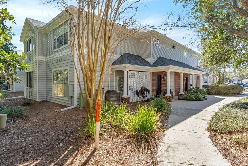 Front exterior of 35103 Harbour Vista Cir, a 2-story condo with grey siding and red brick in St. Augustine, FL.