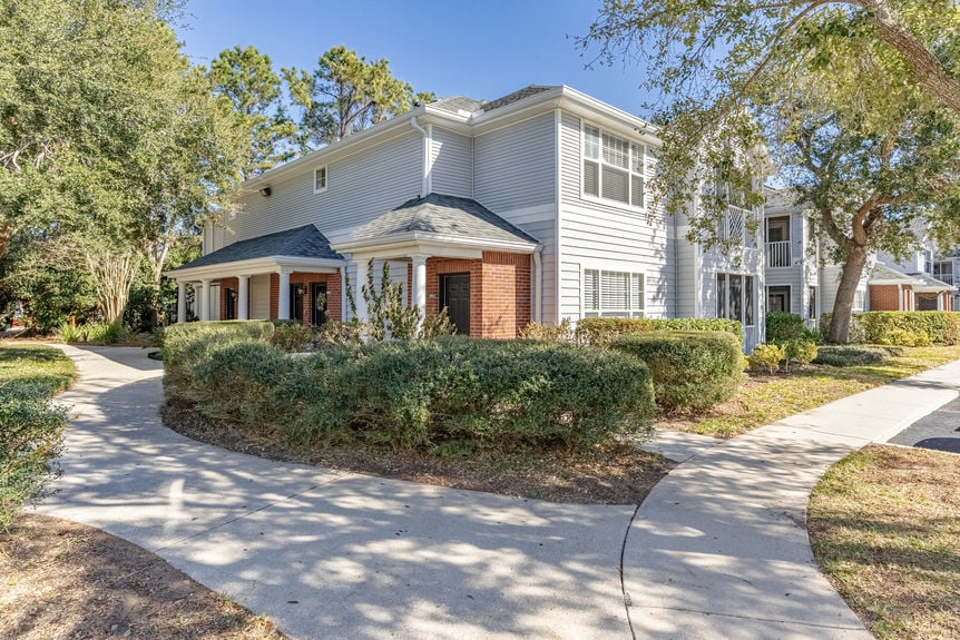 Front exterior of 35103 Harbour Vista Cir, a 2-story condo with grey siding and red brick in St. Augustine, FL.