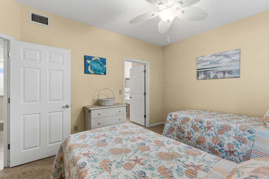 Guest bedroom at 35103 Harbour Vista Cir featuring twin beds, coastal bedding, and white plantation shutters in St. Augustine, FL.