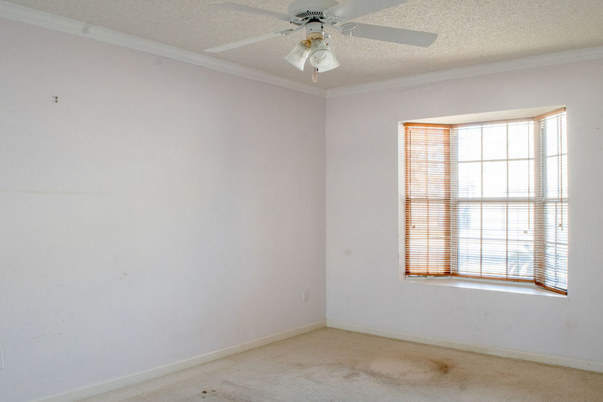 Bright guest bedroom at 364 Village Dr featuring a large architectural bay window and neutral carpet in a gated waterfront neighborhood.