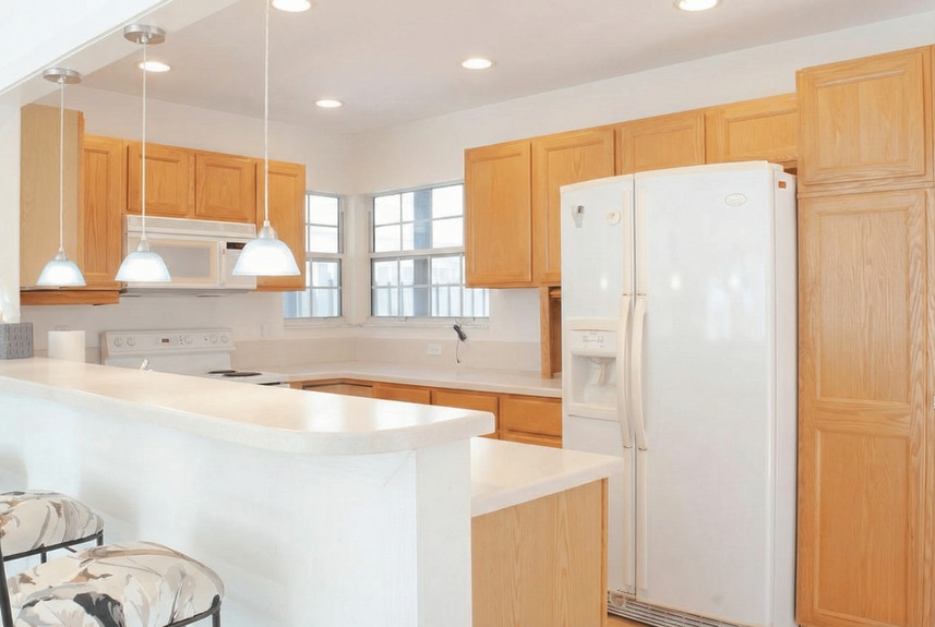 Functional kitchen at 364 Village Dr featuring light oak cabinetry, a raised breakfast bar, built-in wine rack, and pendant lighting with customization potential.