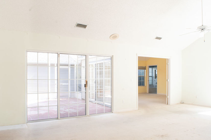 Wide interior view of the open layout at 364 Village Dr showing large sliding glass doors leading to private patios in the gated Villages of Vilano community.