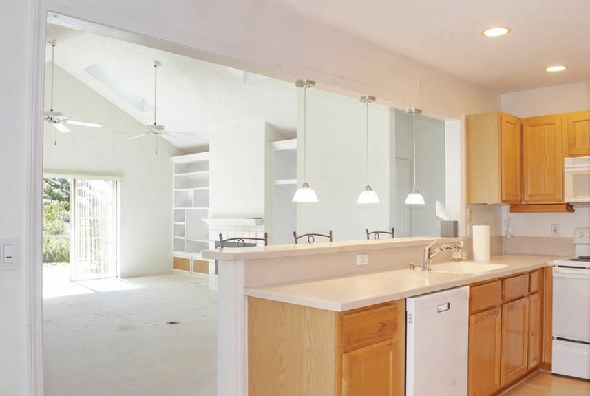 View from the kitchen sink at 364 Village Dr overlooking the living room toward the marsh views, highlighted by natural light from skylights