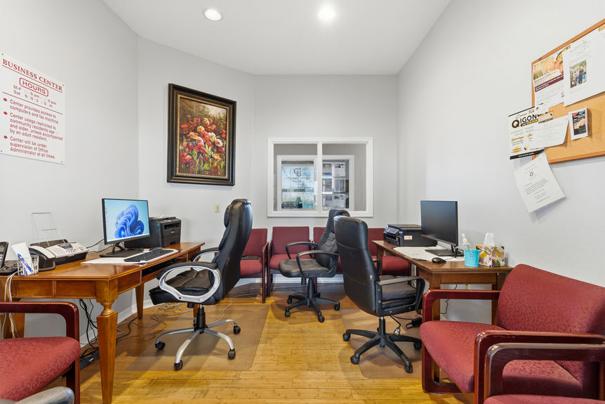 Resident business center at 35103 Harbour Vista Cir, St. Augustine, equipped with multiple computer workstations, printers, a bulletin board, and comfortable office seating.