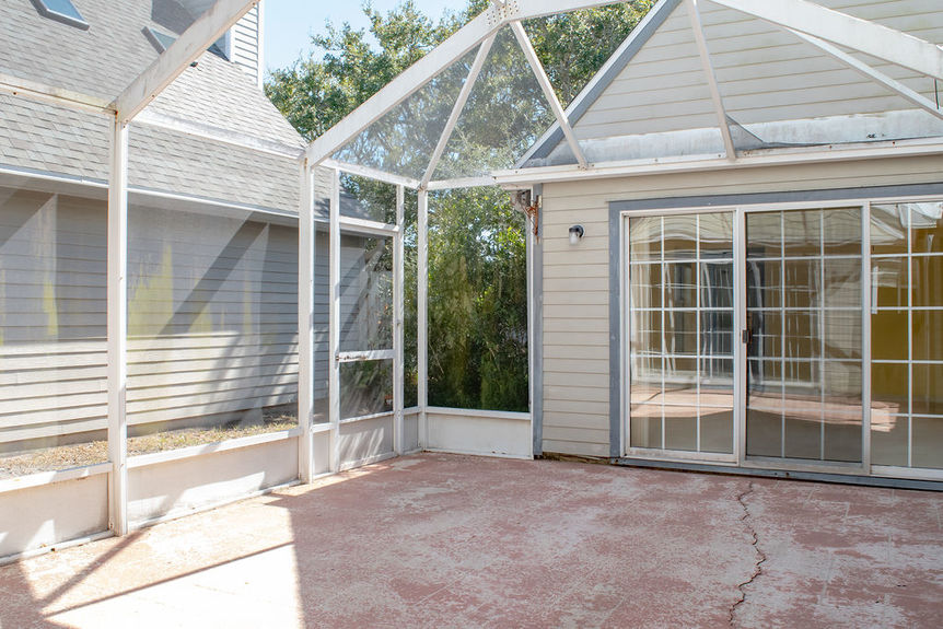 Large screened-in sunroom and open back patio at 364 Village Dr, providing a private space for sunset watching overlooking the natural marsh landscape.