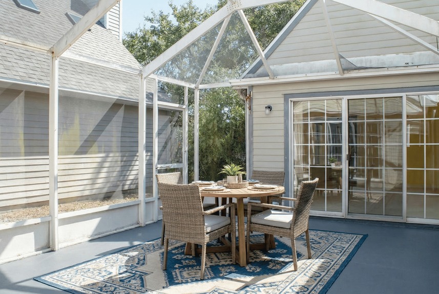 Large screened-in sunroom and open back patio at 364 Village Dr, providing a private space for sunset watching overlooking the natural marsh landscape.