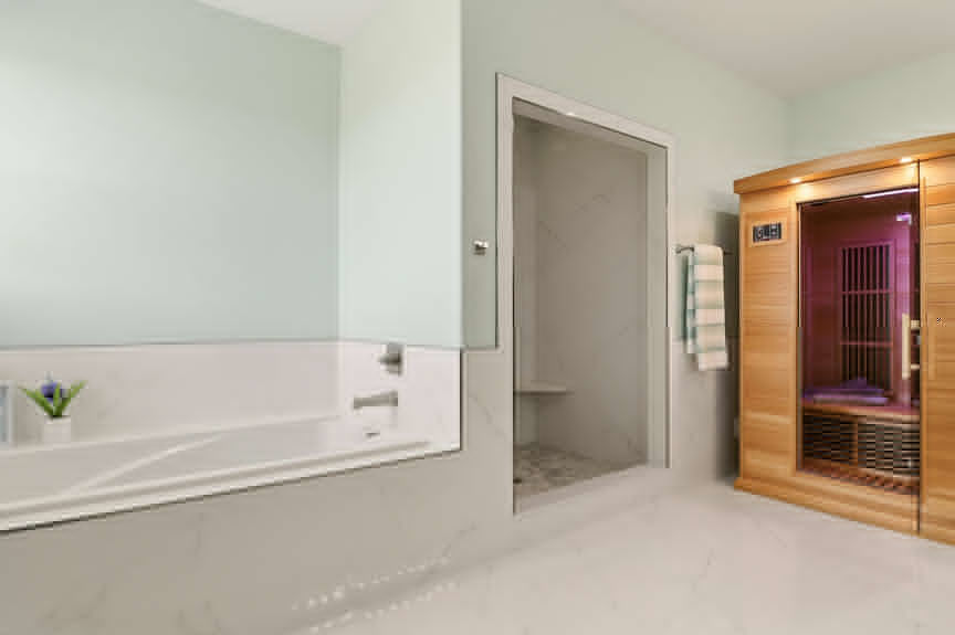 Master bathroom at 5900 Costanero Road featuring a large dark wood double vanity, stone countertops, and a view into the bedroom's fireplace area.