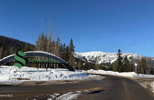 Entrance to Schweitzer Mountain Resort in Sandpoint, Idaho, with snow-covered slopes and evergreen trees in the background. The iconic Schweitzer sign welcomes visitors to North Idaho’s premier ski destination, known for its world-class skiing, snowboarding, and mountain recreation.