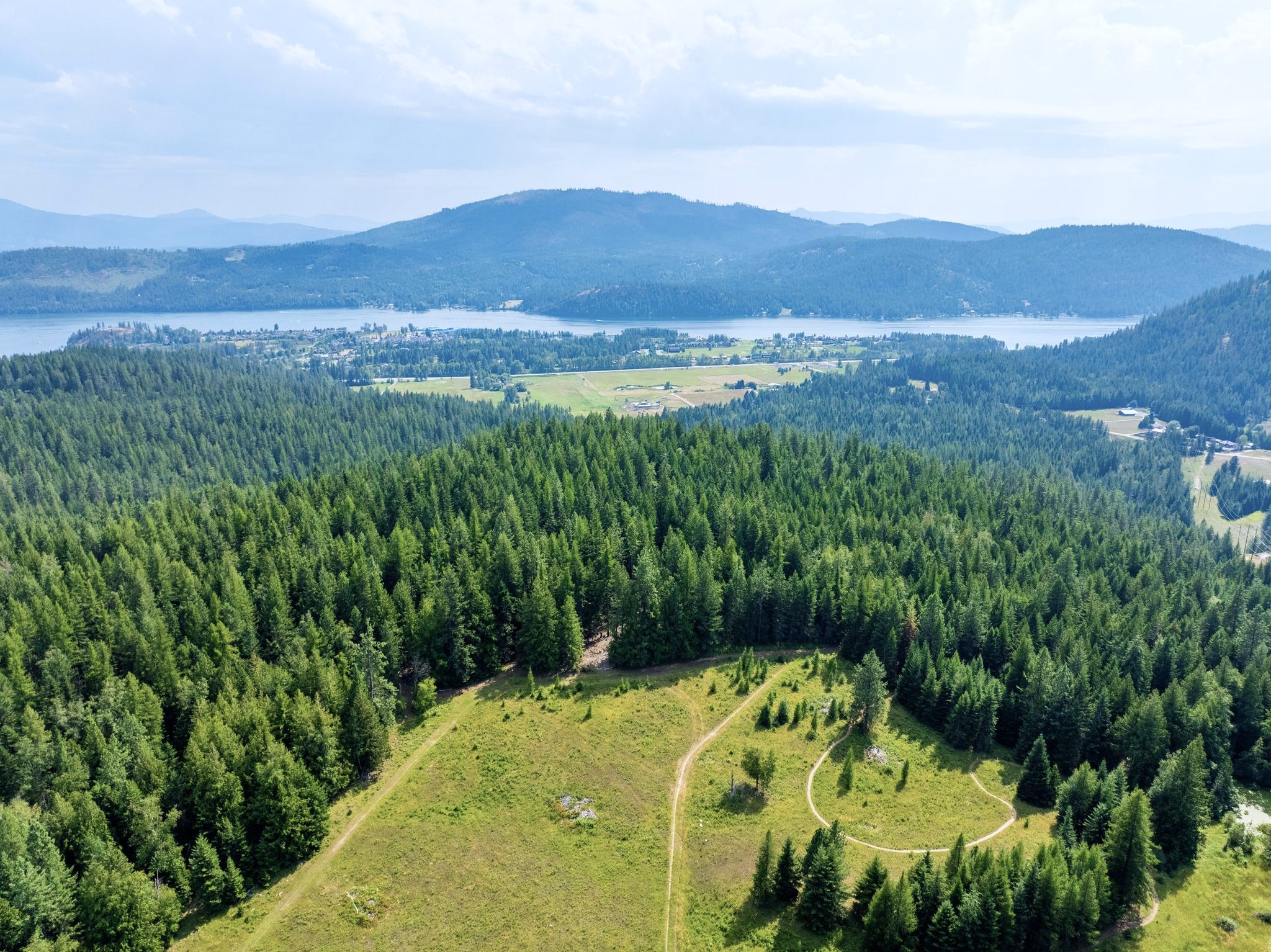 an aerial photo of pine street woods in Sandpoint idaho. you can see Lake Pend Oreille, the mountains and a blue sky