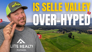 A photo of Ben Geanetta, a realtor in Sandpoint, with the words "is selle valley over-hyped." in the background, green grass, with big fields, trees and Lake Pend Oreille.
