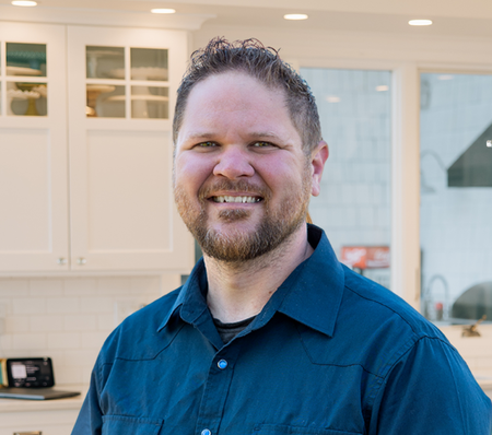 a photo of Ben Geanetta in a kitchen with white cabinets