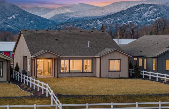 Twilight photo with schweitzer mountain in the background and the backyard of a house
