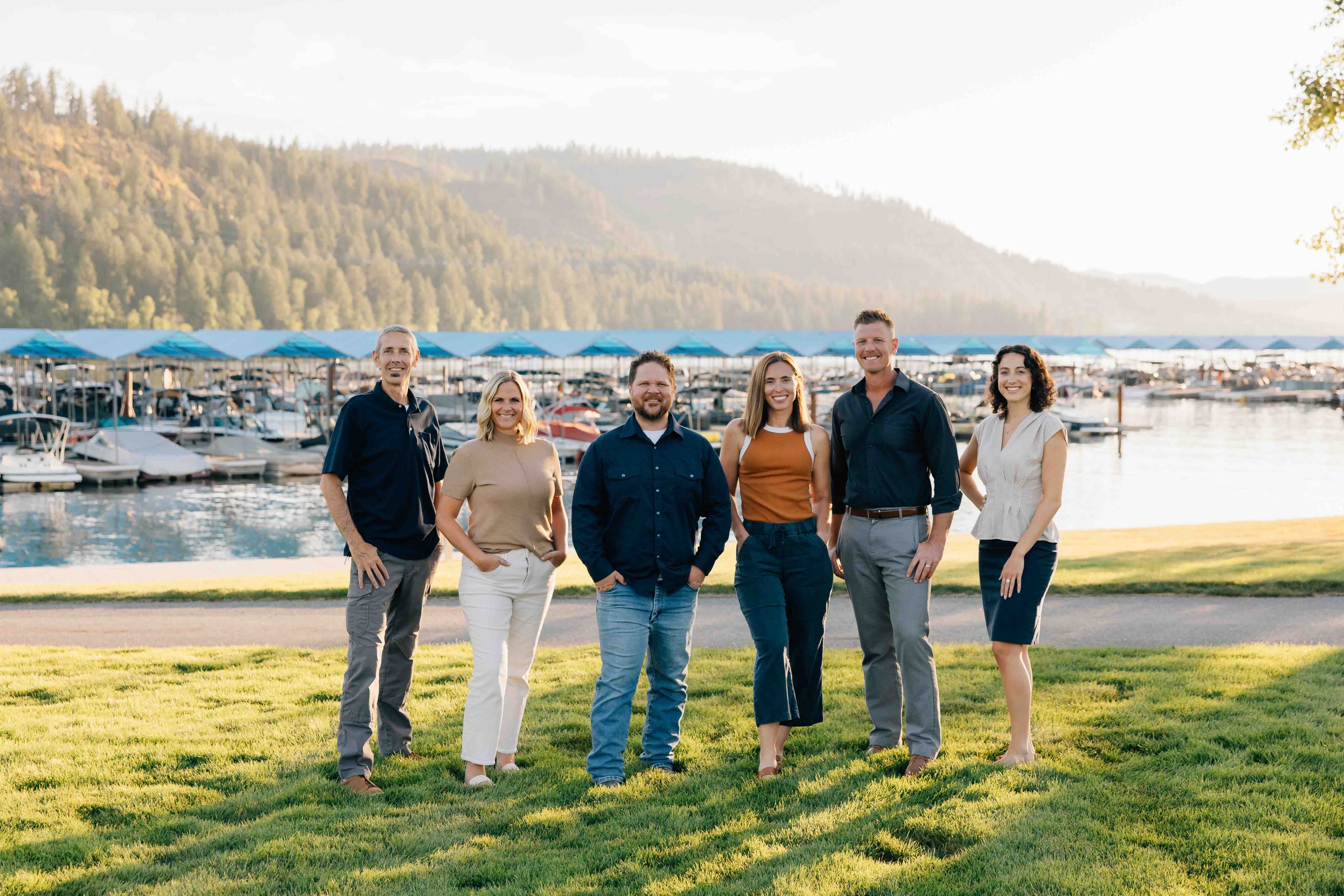 group photo of sandpoint idaho top realtors, Elite Realty Partners, outside at dusk with marina in background