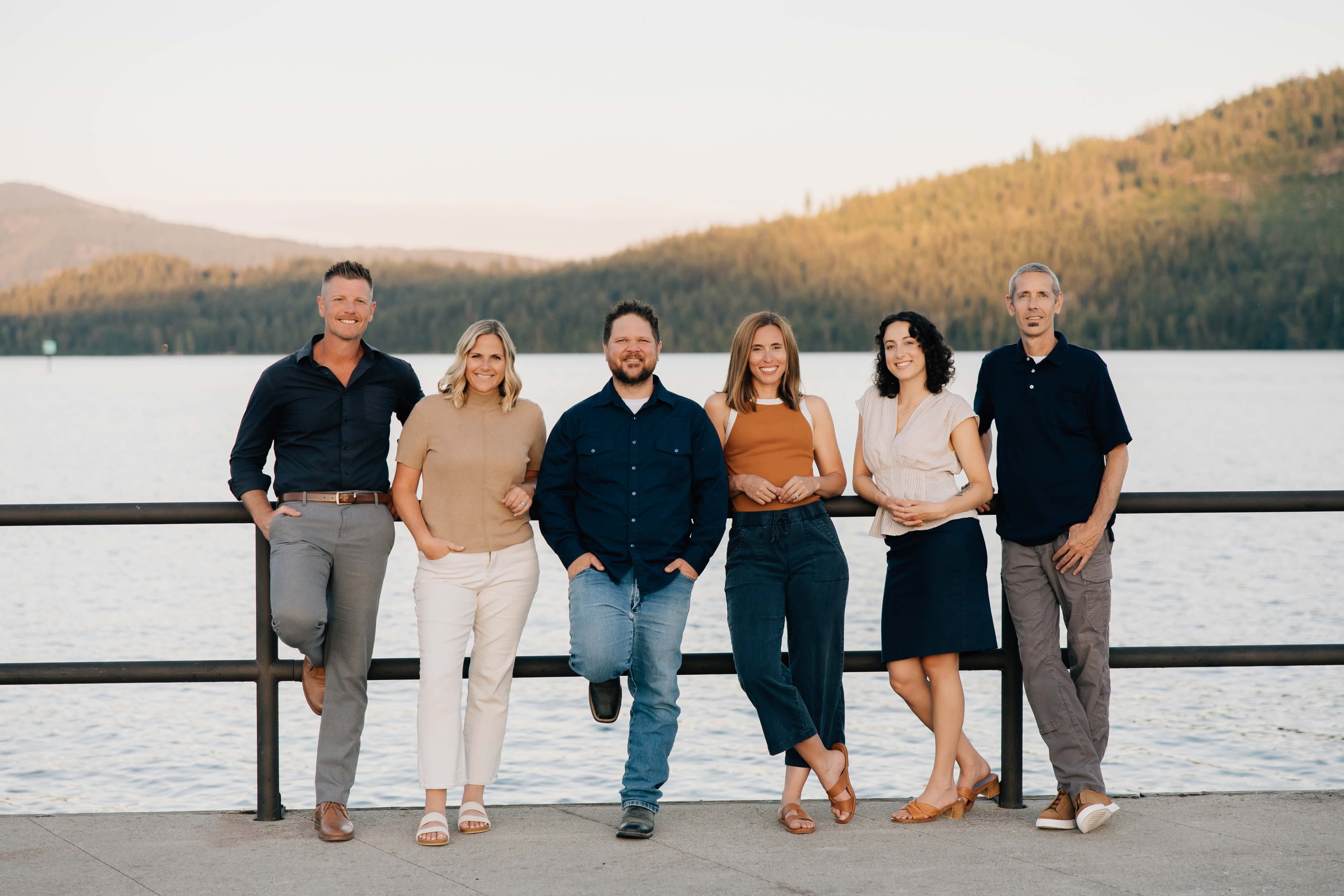 group photo of sandpoint idaho top realtors, Elite Realty Partners, outside at dusk with marina in background
