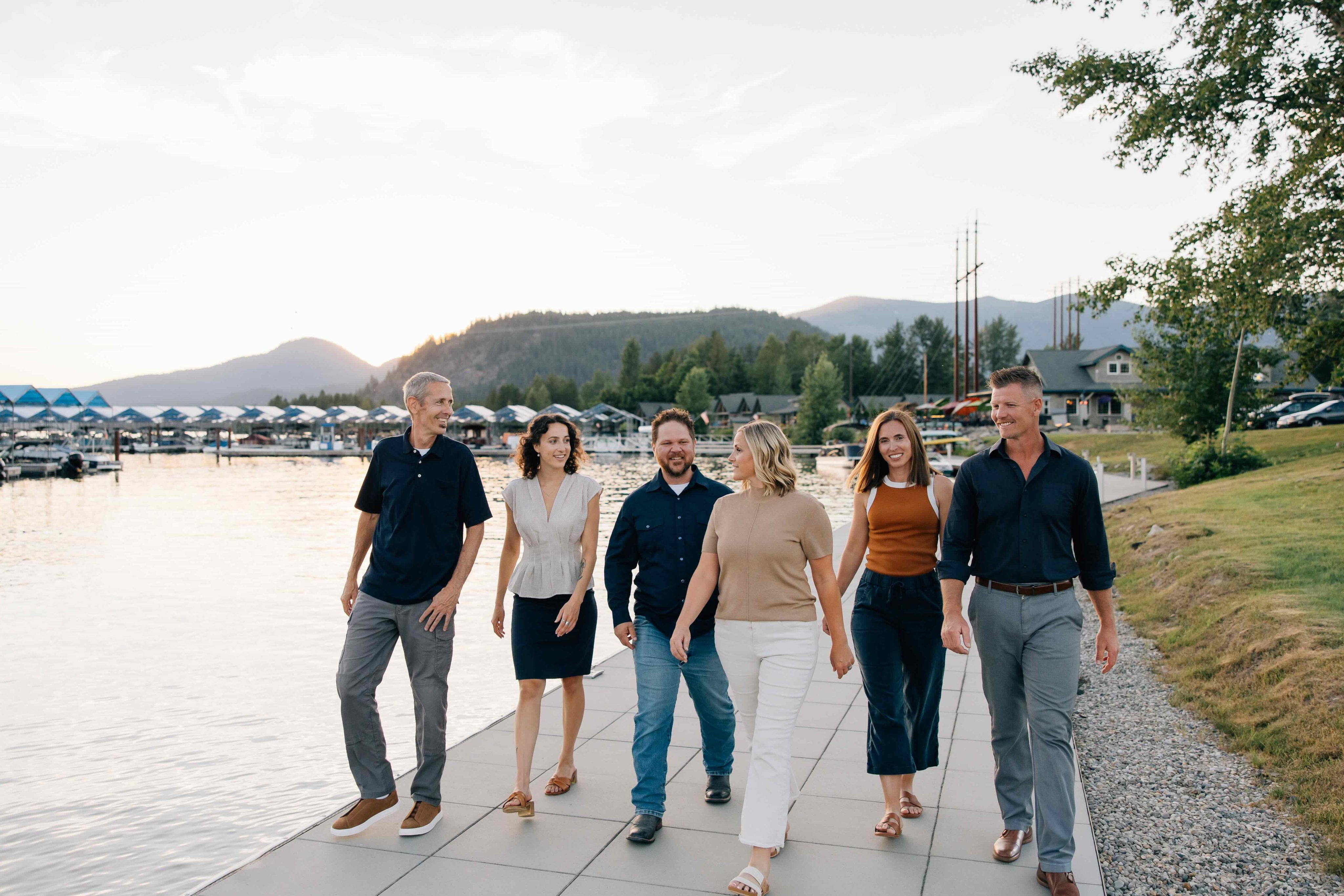 group photo of sandpoint idaho top realtors, Elite Realty Partners, outside at dusk with marina in background