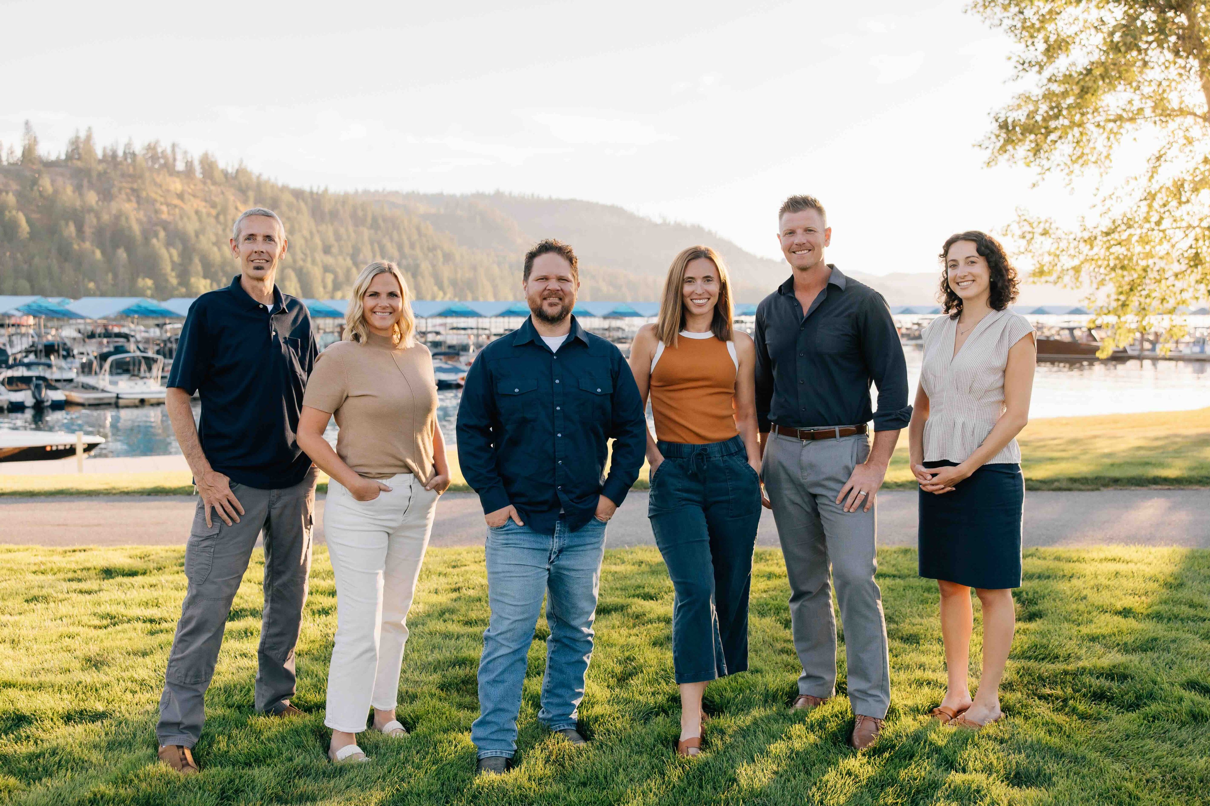 group photo of sandpoint idaho top realtors, Elite Realty Partners, outside at dusk with marina in background