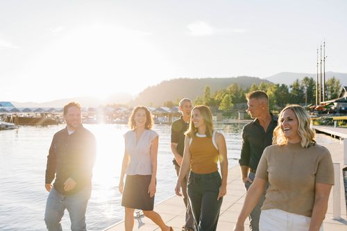 group photo of sandpoint idaho top realtors, Elite Realty Partners, outside at dusk with marina in background
