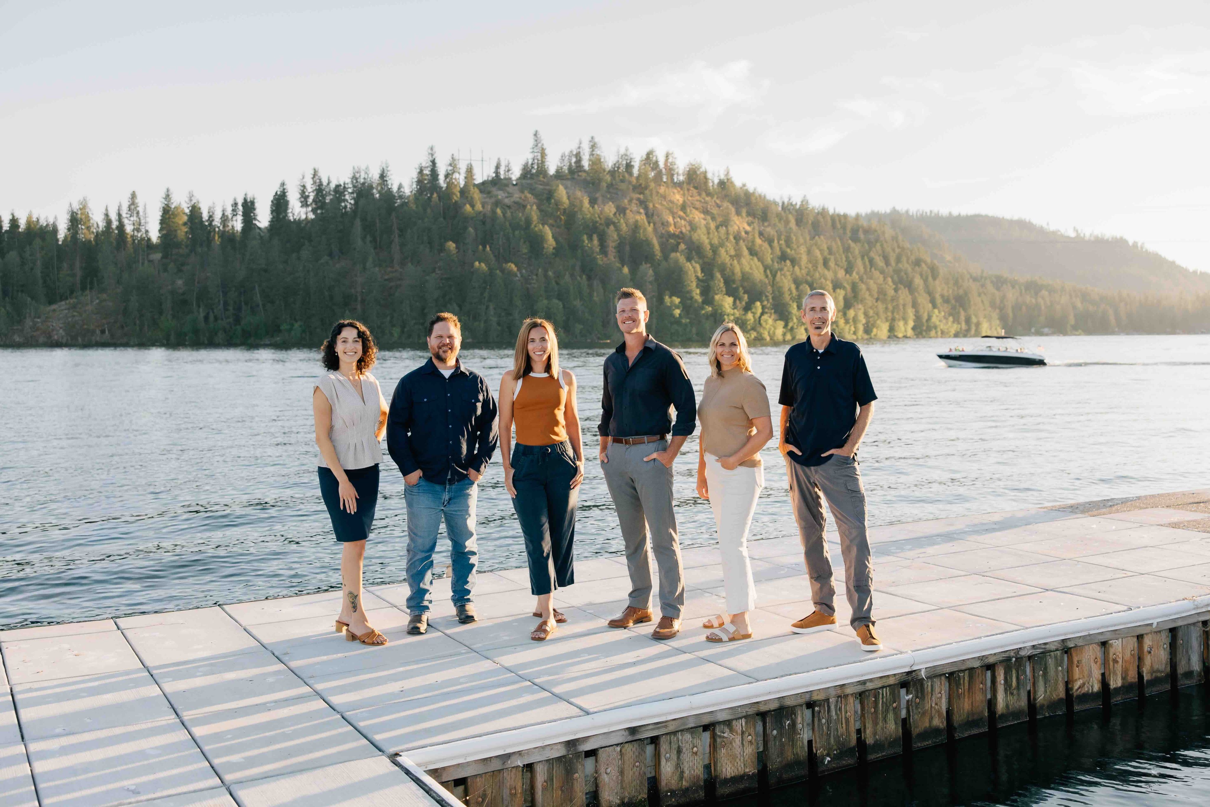group photo of sandpoint idaho top realtors, Elite Realty Partners, outside at dusk with marina in background