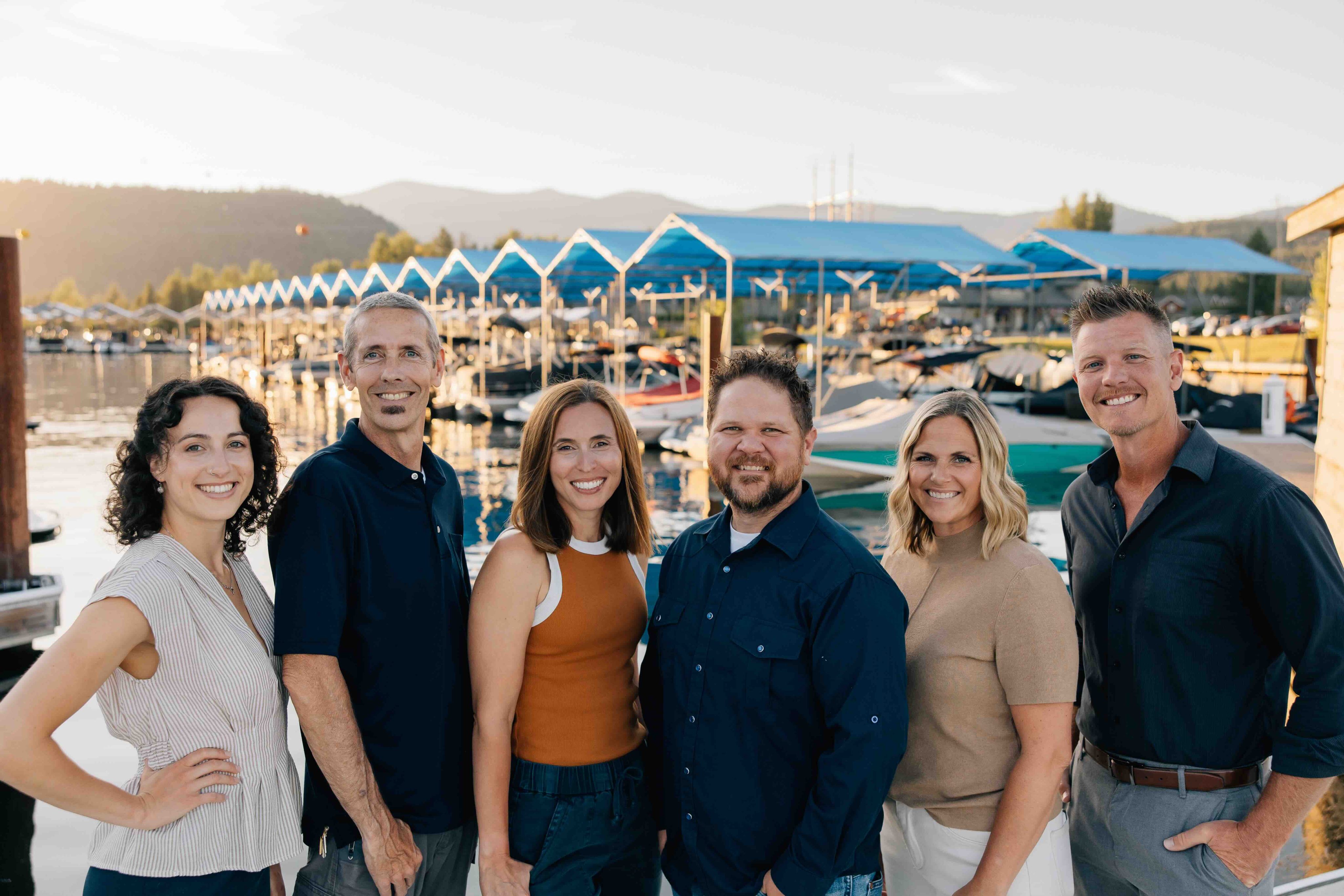 group photo of sandpoint idaho top realtors, Elite Realty Partners, outside at dusk with marina in background