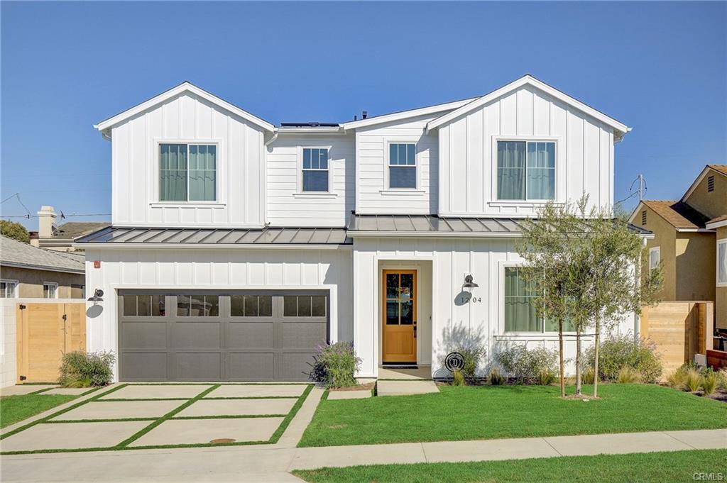 A white two-story modern farmhouse-style new home with a gray garage door, an example of a pre-designed new home offering limited changes