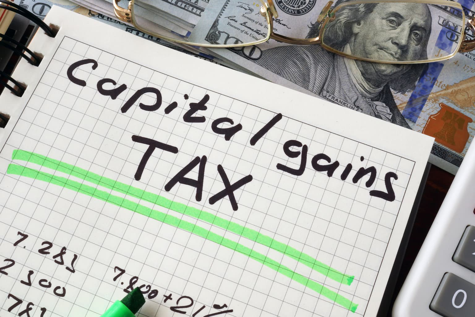 A notebook with a "capital gains TAX" written on it.