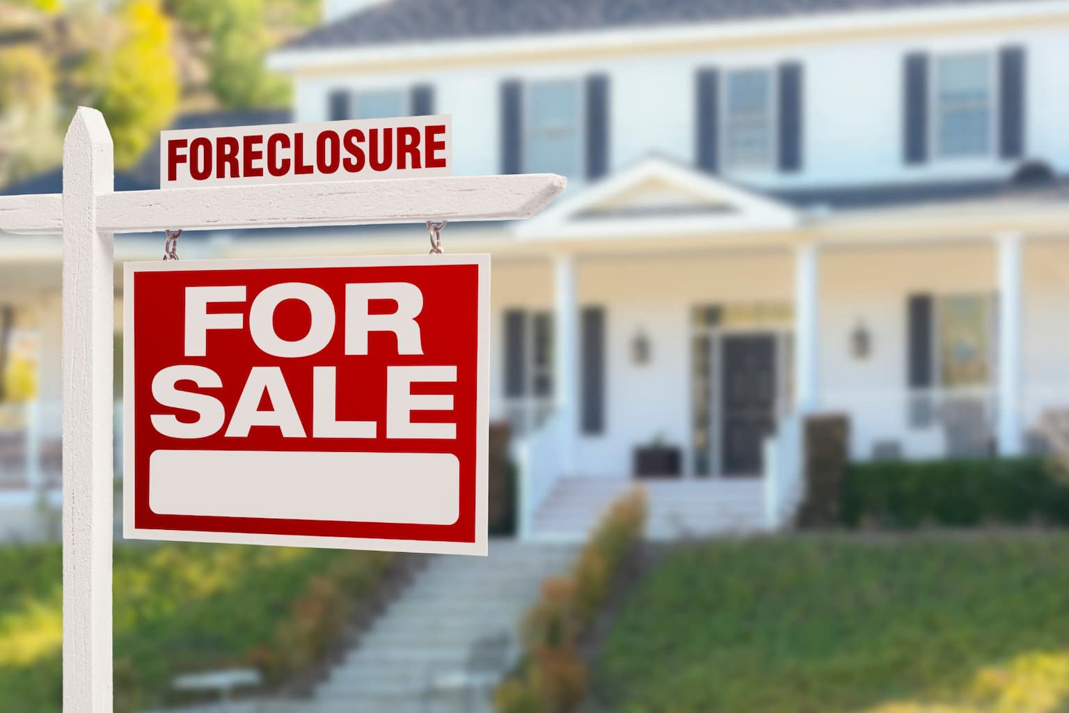 outside a house with a ‘For Sale’ sign, looking concerned about foreclosure