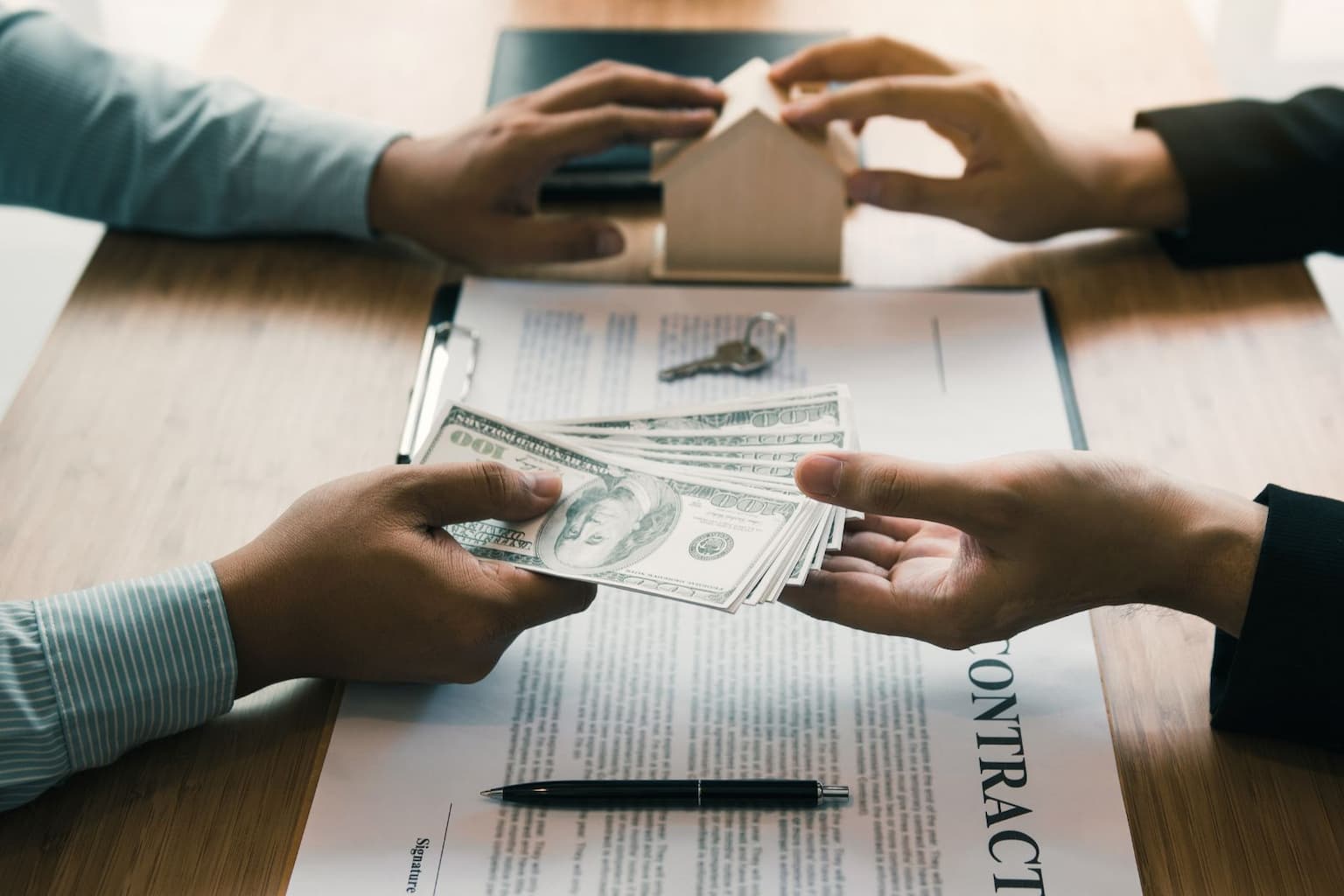 Person handing over cash for a house sale