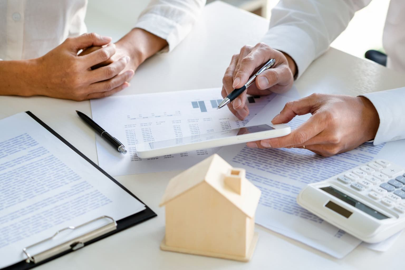 Hands comparing multiple real estate offers on paper