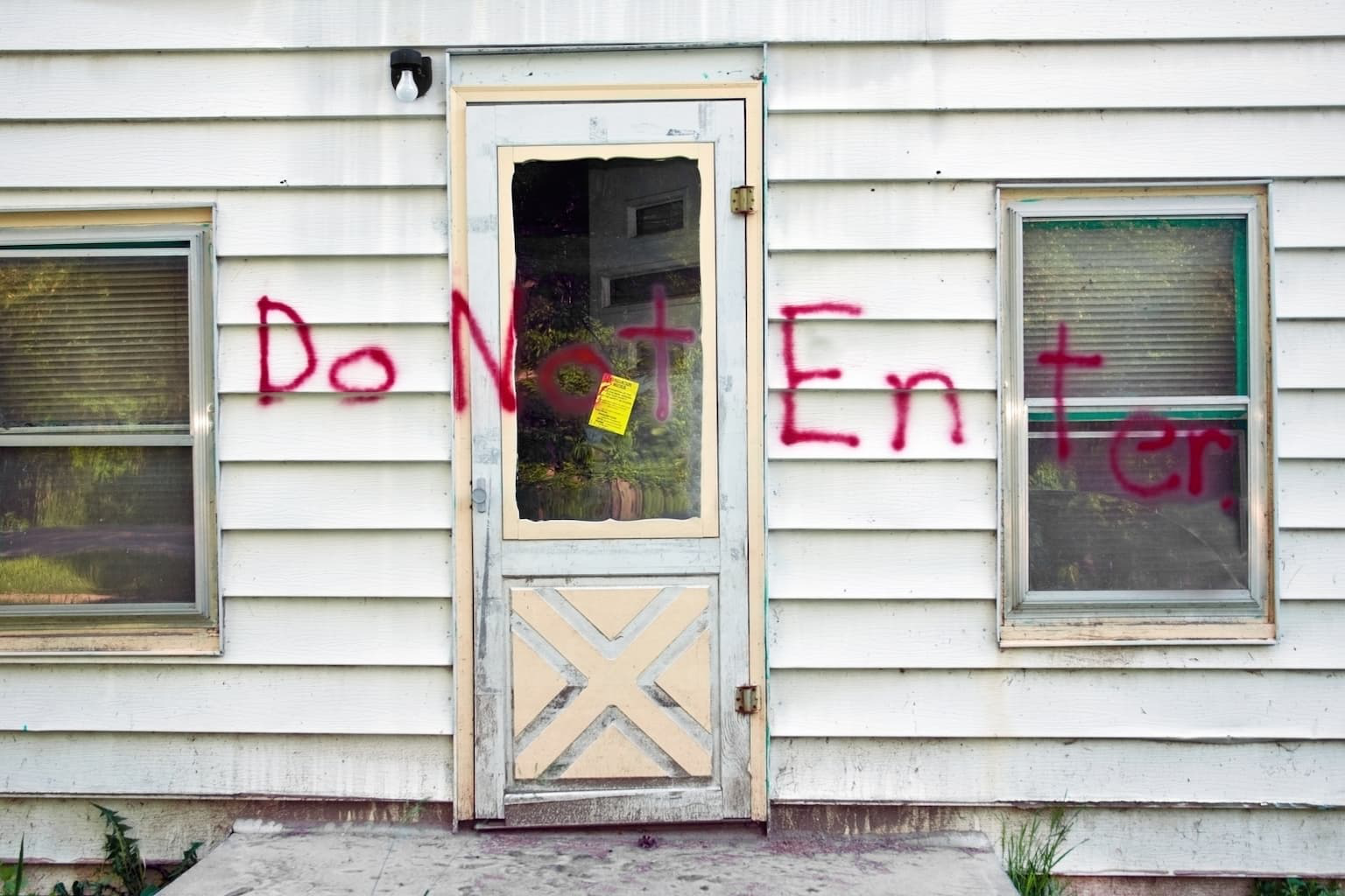 Exterior of a condemned house in California with warning signs
