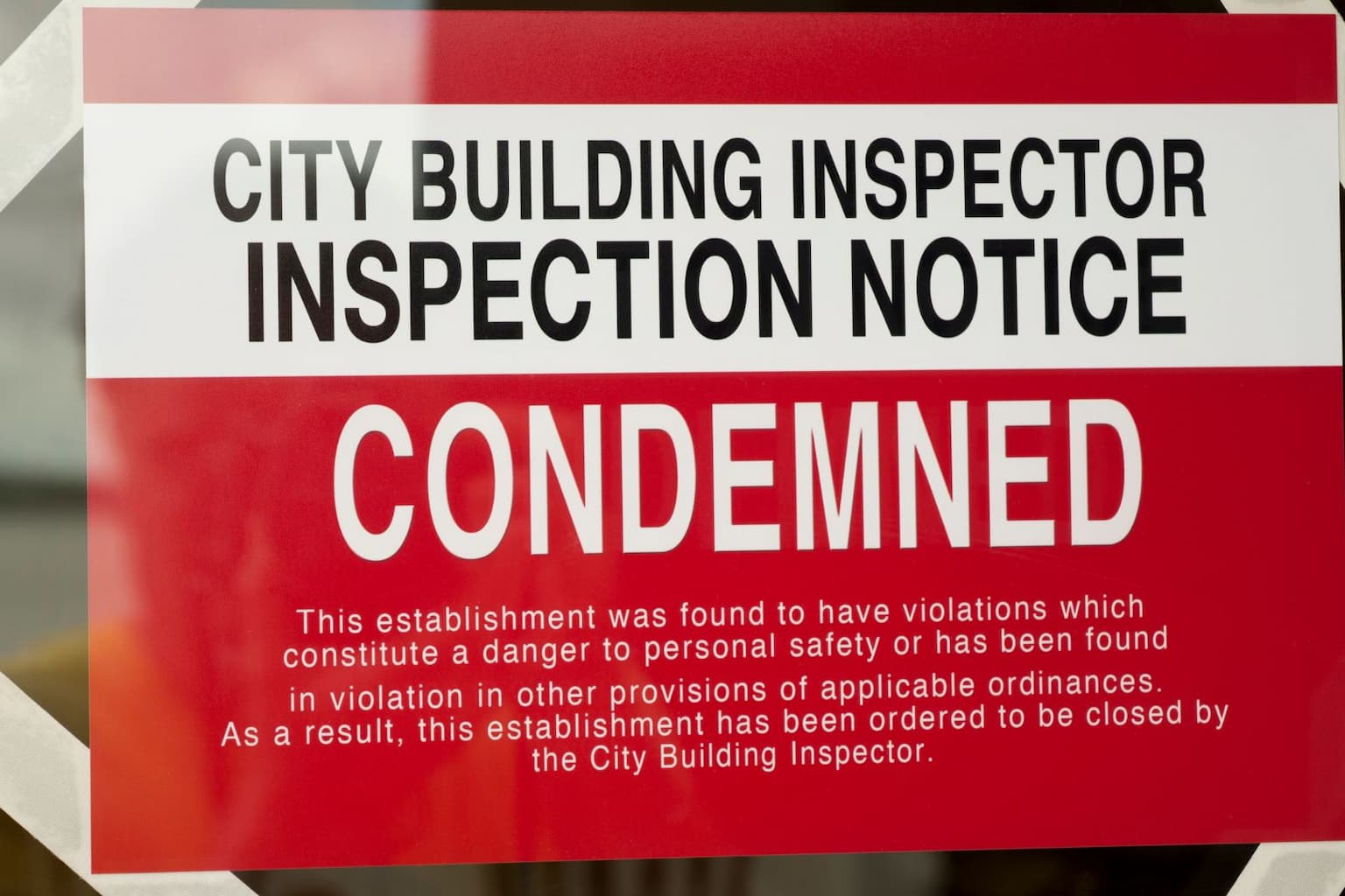 Red sign showing a house marked as condemned